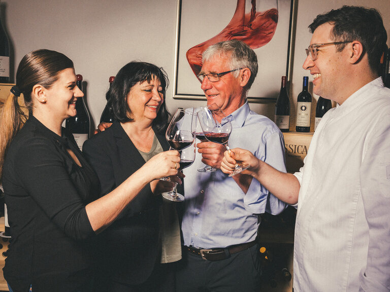 Die Gastgeberfamilie Behl stösst gemeinsam mit einem guten Glas Wein an.